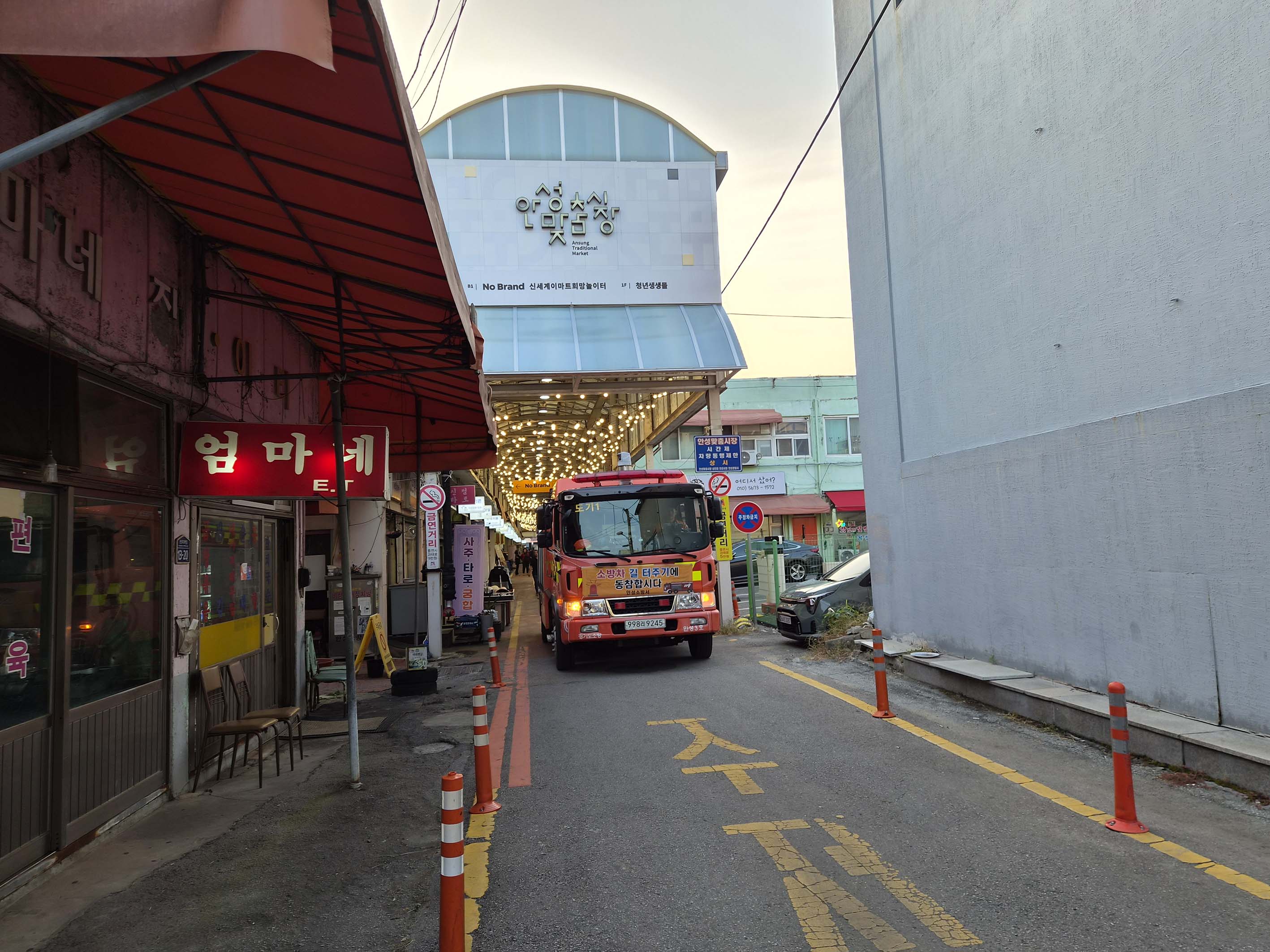 아치형 간판이 보이는 안성맞춤시장 입구 골목에 서 있는 소방차