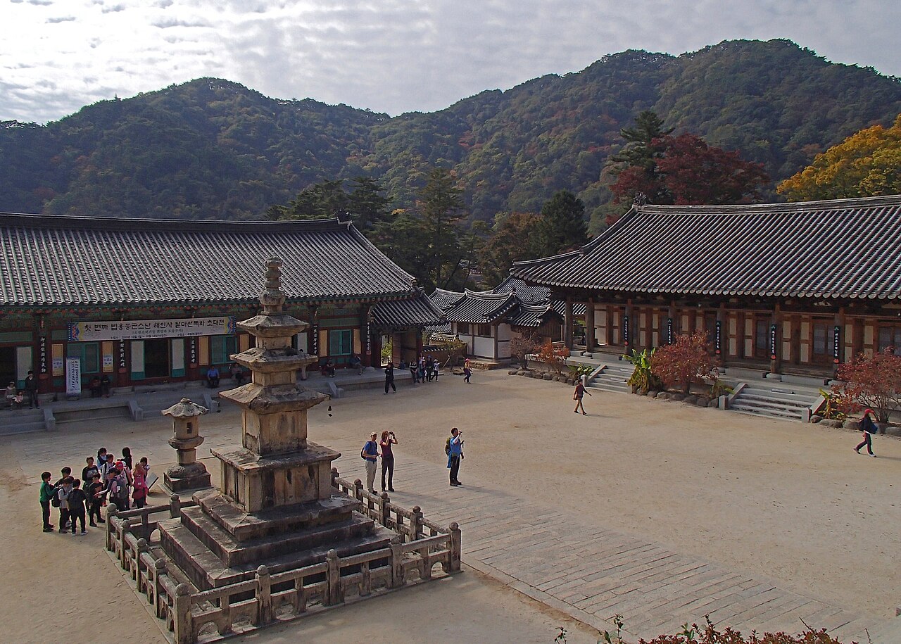 물들기 시작한 산을 배경으로 한 해인사 마당과 석탑