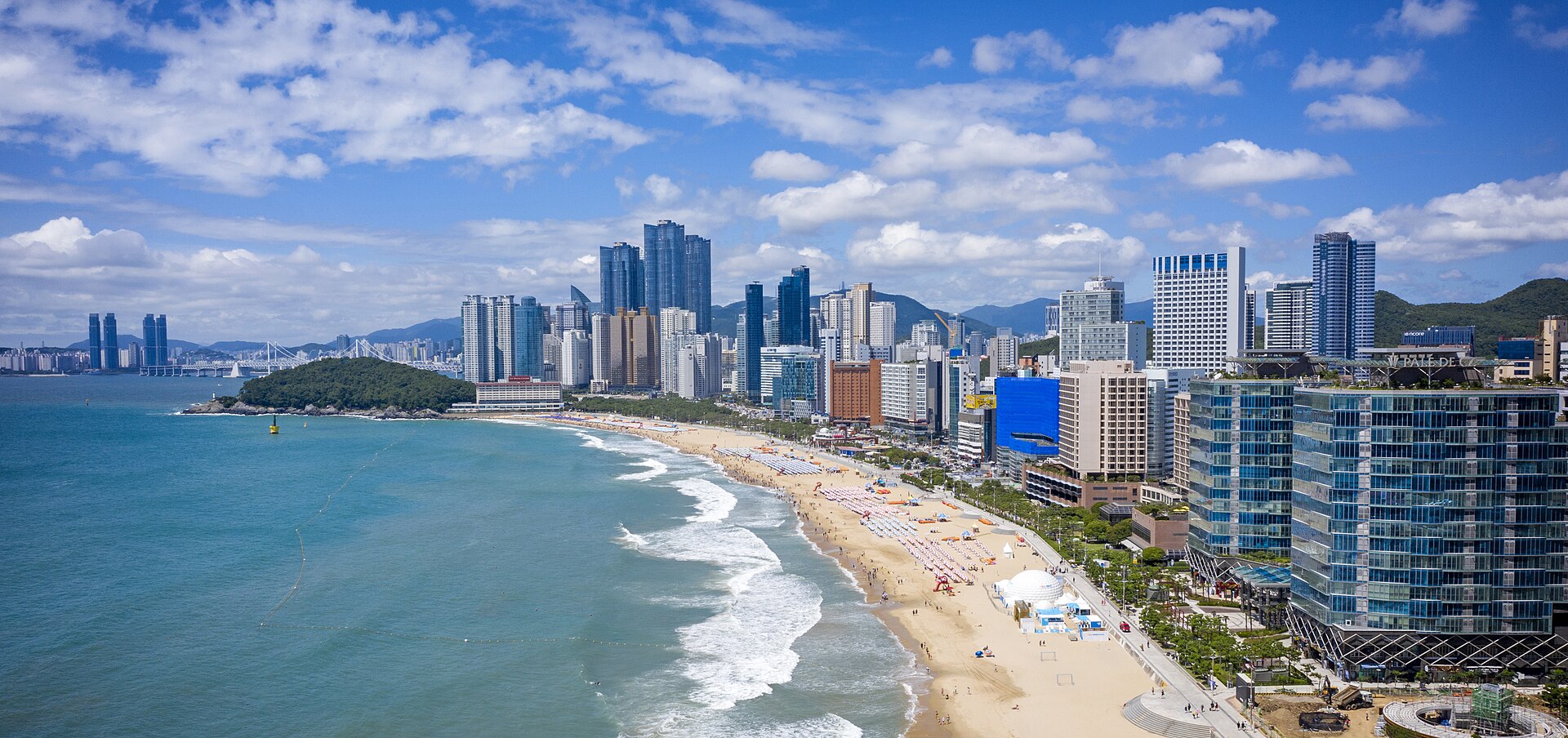 Blue sea and sandy beach with Haeundae high-rises lining the shore