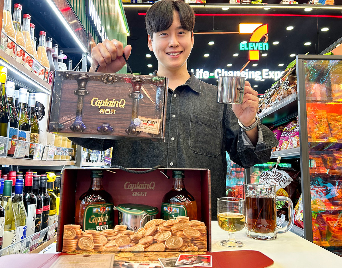 캪틴큐 보물상자 패키지를 든 모델과 세븐일레븐 매장