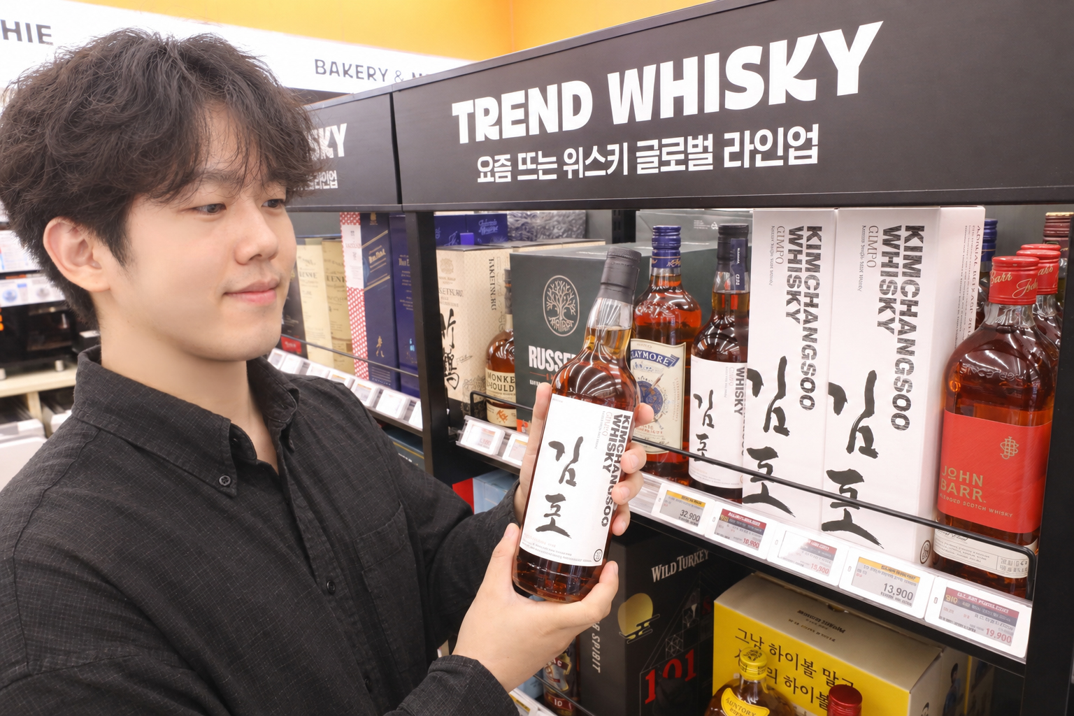 TREND WHISKY 진열대에서 김포 병을 살펴보는 모습