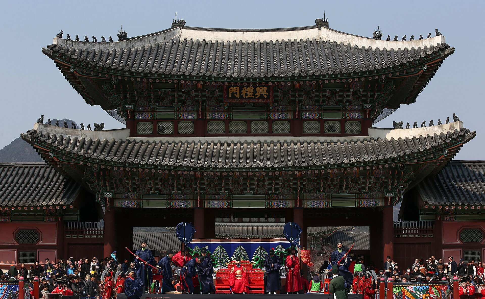 Spectators watching the ritual under the gate eaves