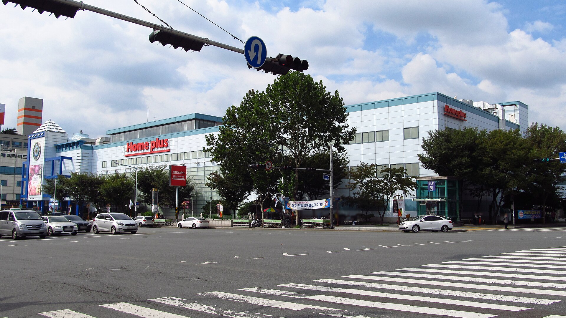A Homeplus store building seen from across an intersection