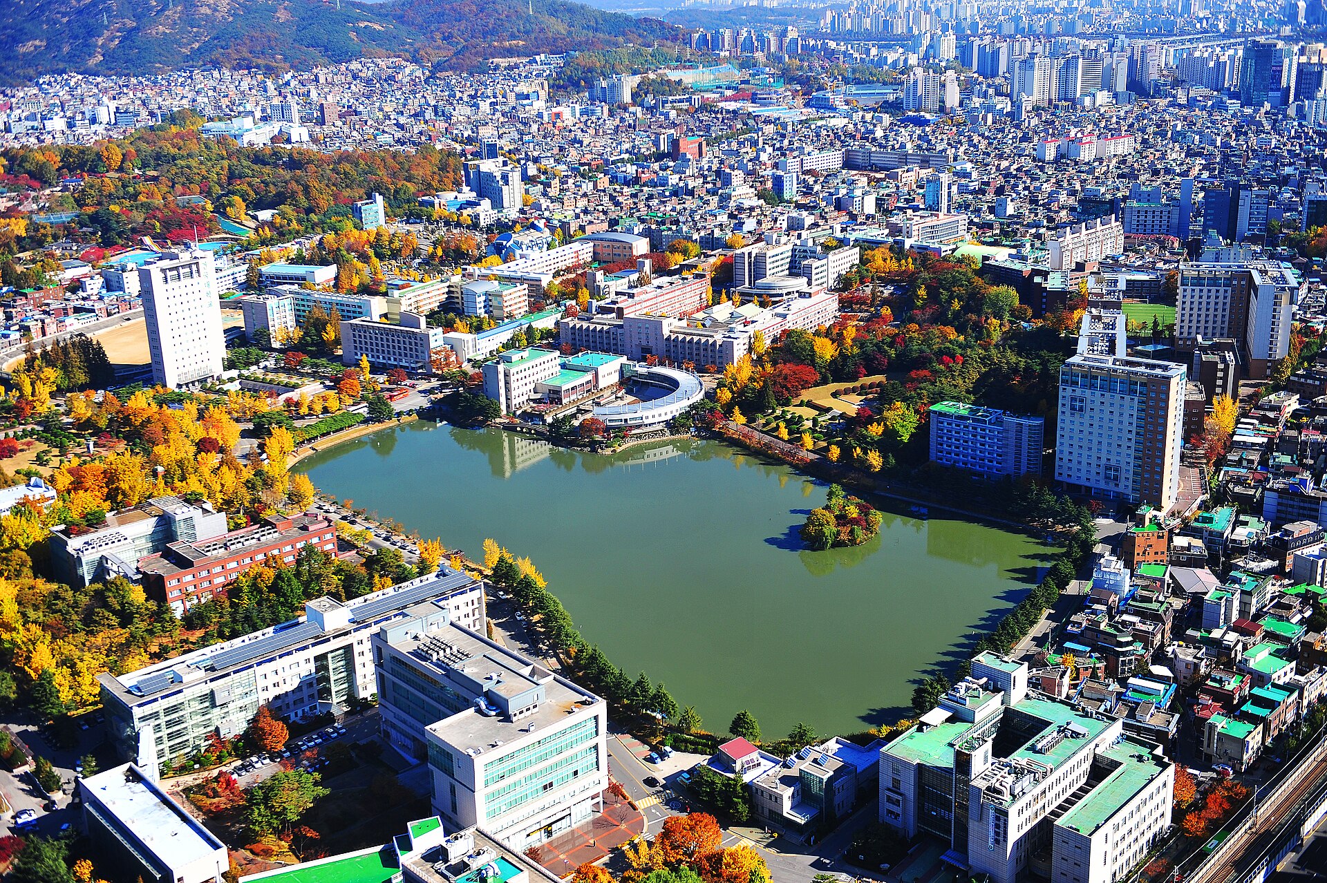 호수를 둘러싼 캠퍼스 건물과 단풍 든 나무를 위에서 내려다본 모습