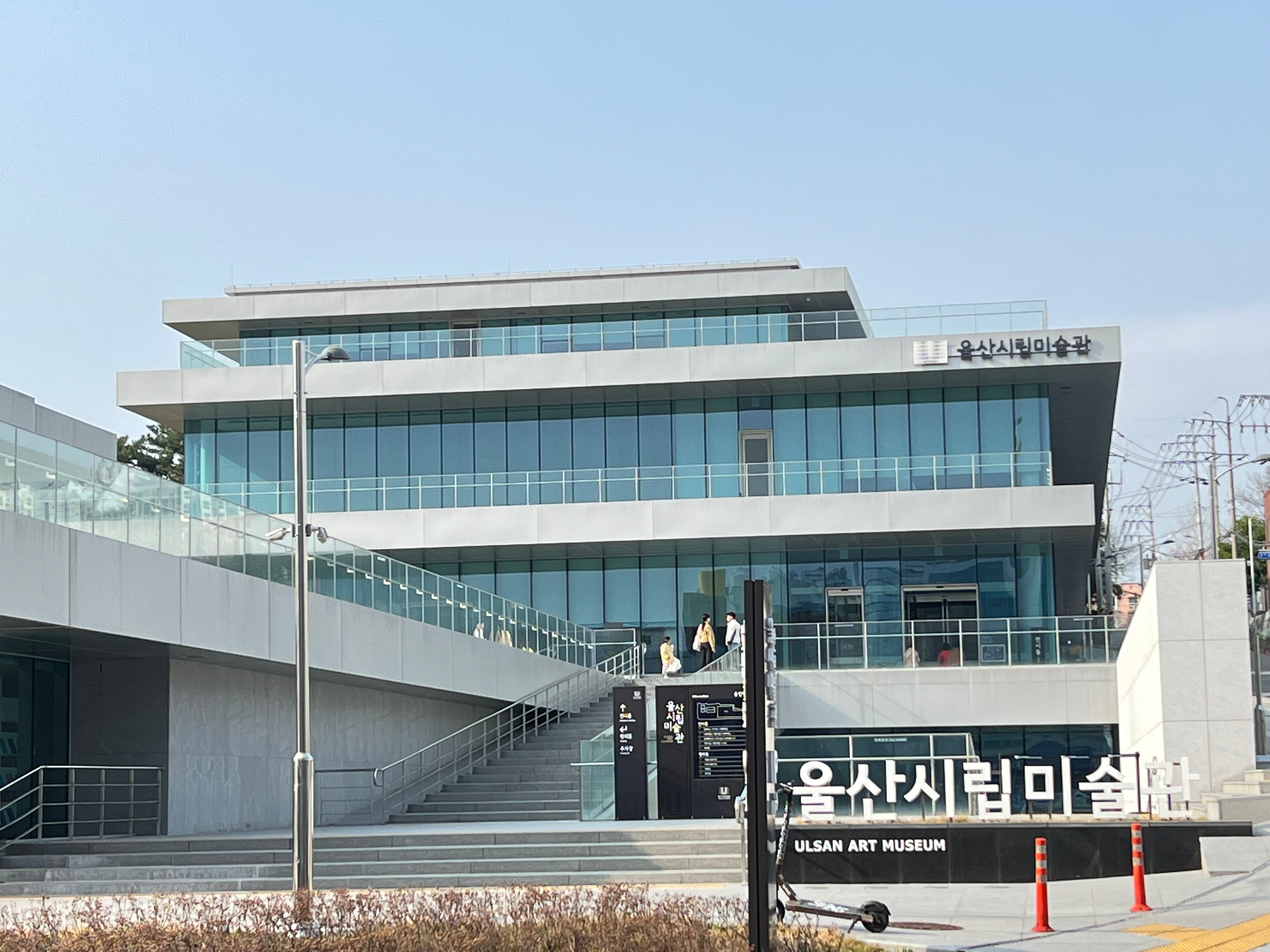 울산시립미술관 이름이 표시된 유리와 콘크리트 건물 외관 및 출입구 계단