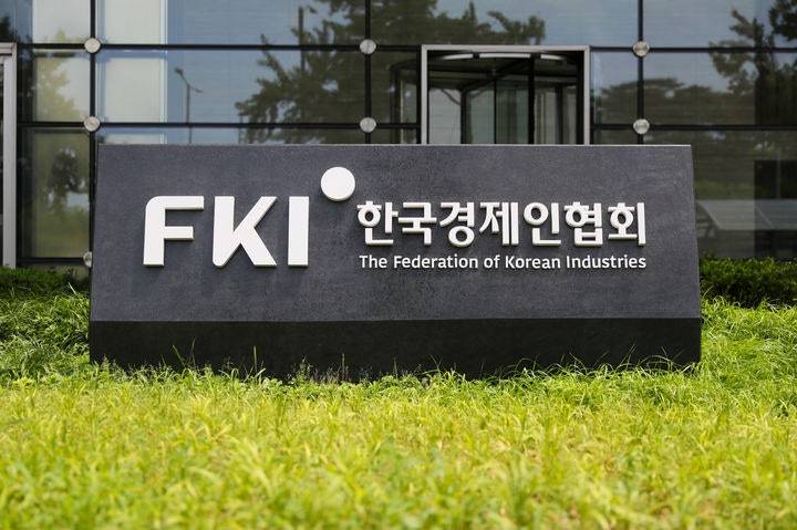 유리 건물 앞 잔디에 놓인 한국경제인협회 표지석