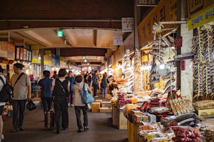 広蔵市場の屋内通路を歩く人々と乾物・食品の店