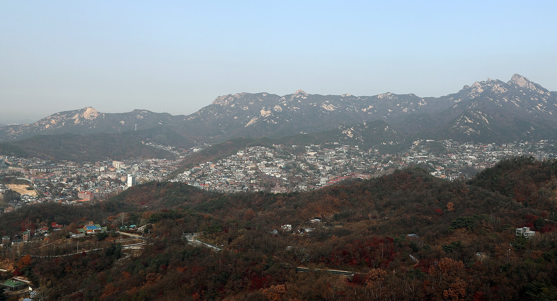 북악산 위에서 본 평창동 주택가 너머로 북한산 능선이 이어지는 늦가을 풍경