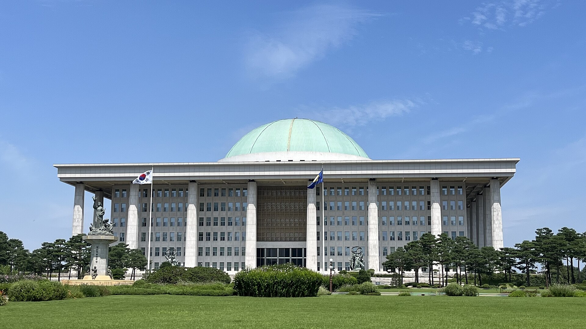 푸른 하늘 아래 돔 지붕을 얹은 국회의사당 건물 전경