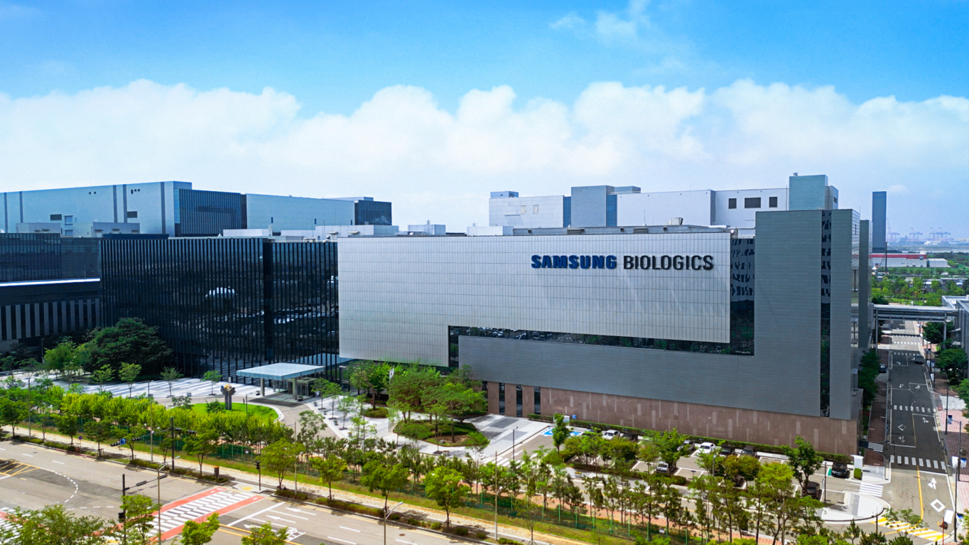 푸른 하늘 아래 'SAMSUNG BIOLOGICS' 간판이 붙은 대형 공장 건물