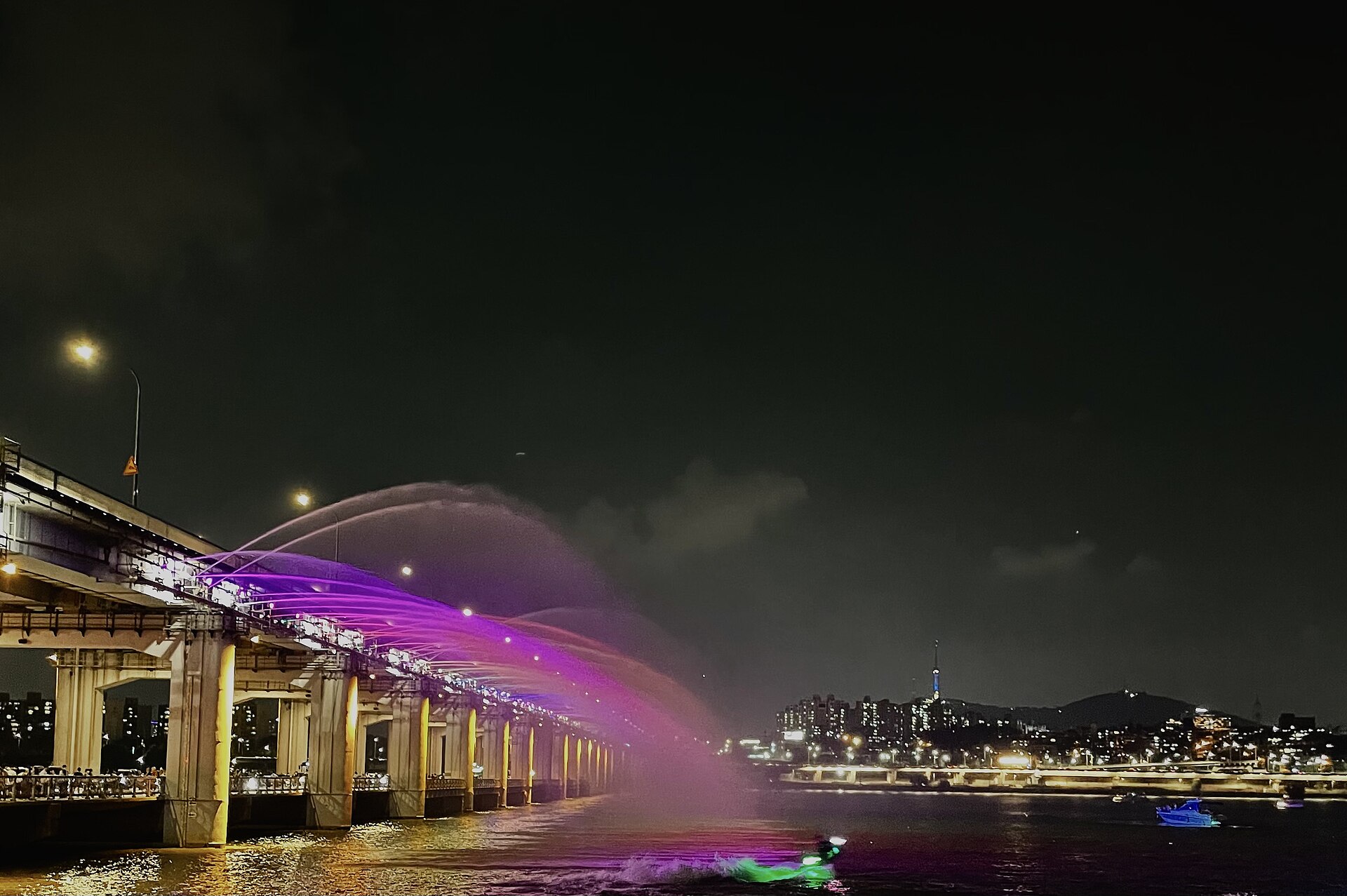 다리에서 뻗은 보라색 물줄기와 멀리 보이는 남산서울타워 야경