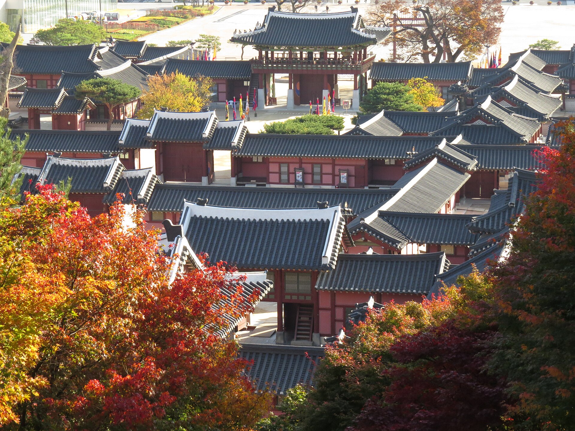 赤い紅葉の向こうに見える行宮の灰色の瓦屋根と楼門