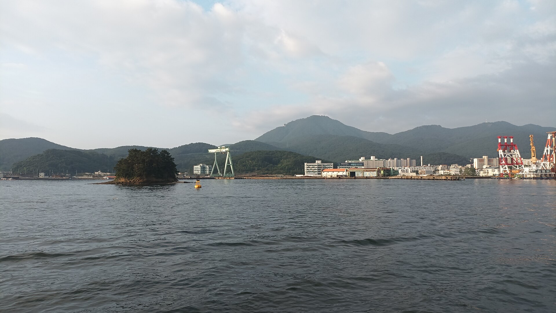 The sea off Tongyeong with a small island and the port below the hills