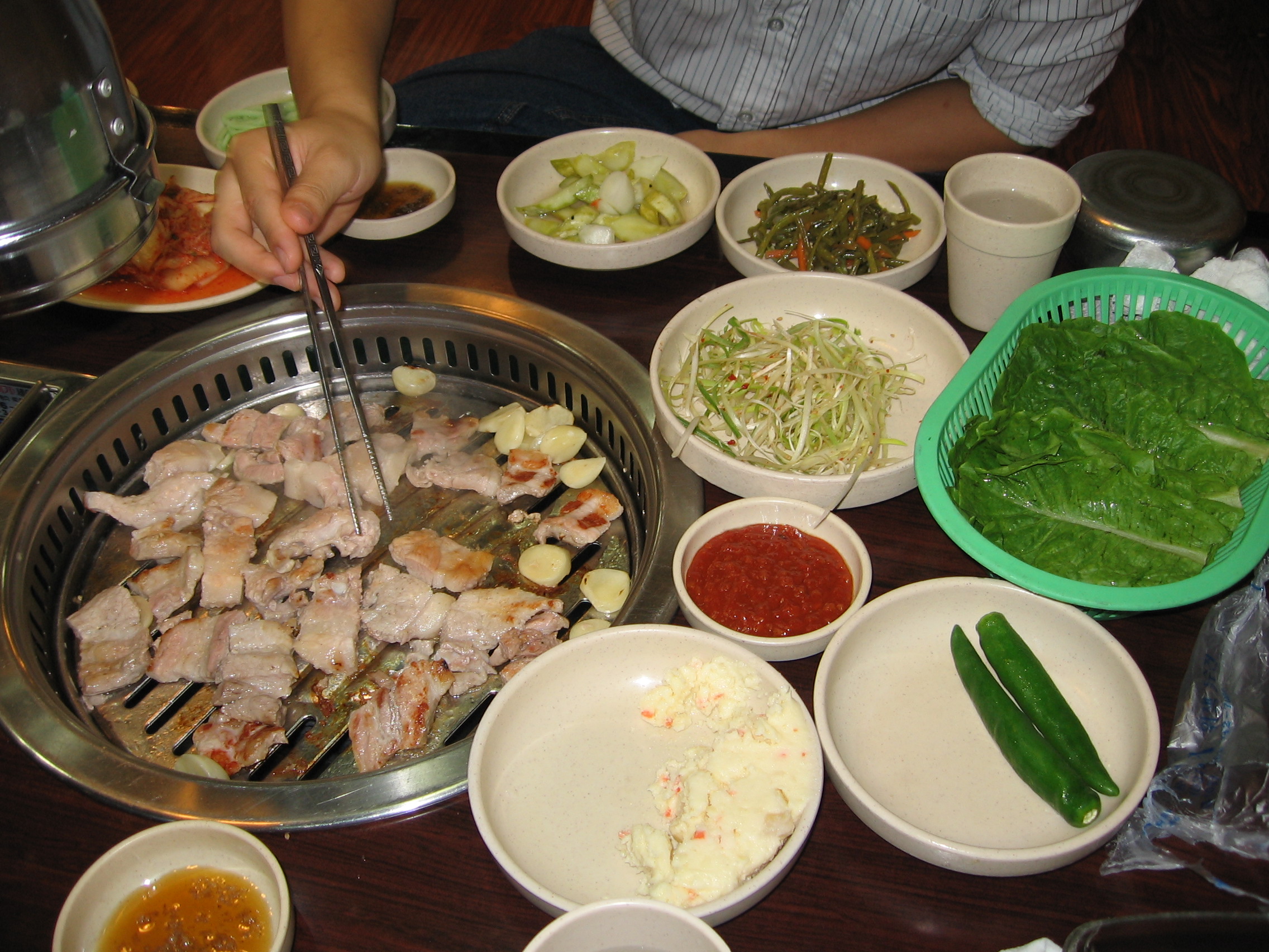 2005년 서울 식당의 불판 위 고기와 반찬이 차려진 식탁