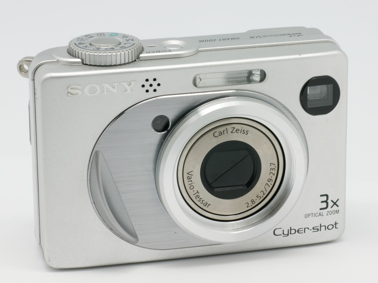 회색 배경 앞 은색 Sony Cyber-shot DSC-W1의 렌즈와 상단 조작 다이얼